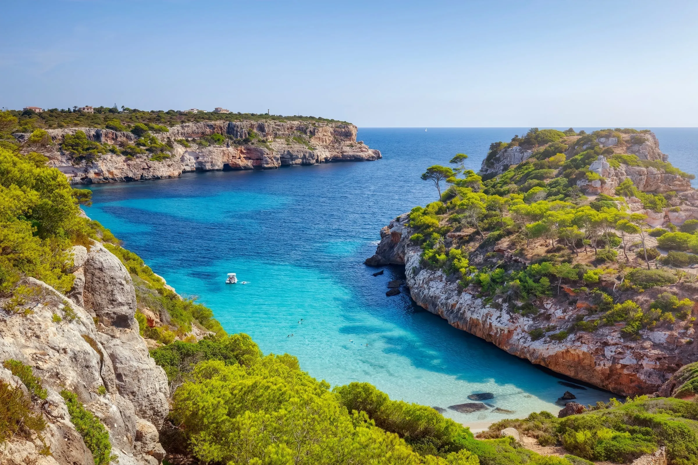 Caló des Moro showing turquoise water and crowded rocky shores